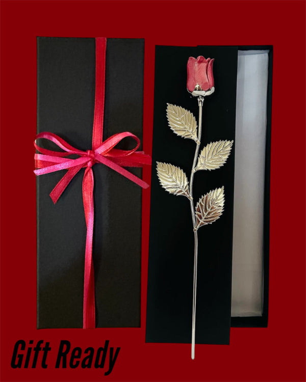 Decorative rose with gold leaves in a black box with a red ribbon gift ready