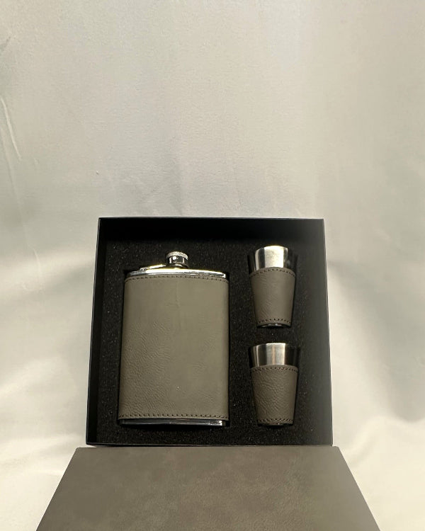 Gray flask set with two cups in a black box on a light gray background