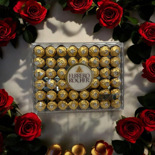 Box of Ferrero Rocher chocolates surrounded by red roses on a light background