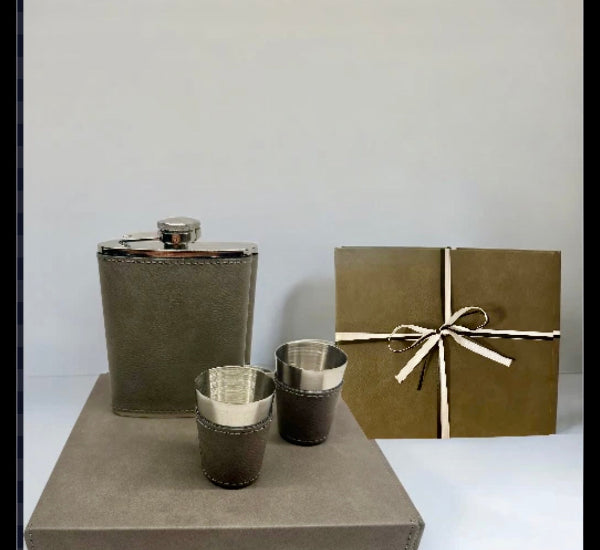 Set of brown leather flask and cups with matching gift box on a white background