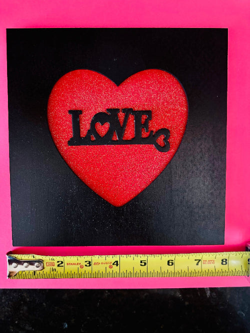 Red heart-shaped patch with 'LOVE' text on a black background, measured against a pink border.