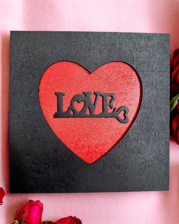 Red heart with 'LOVE' text on a black background surrounded by red roses.