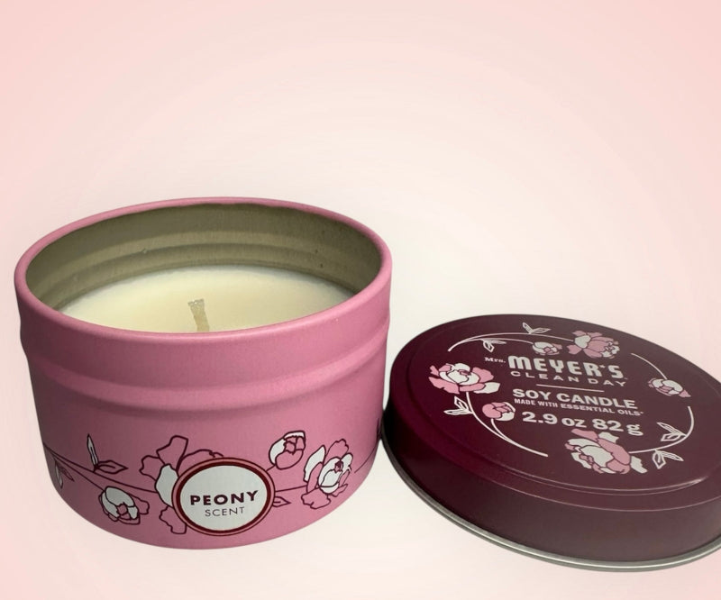 Pink candle tin with 'Mever's' branding and 'Peony' scent on a pink background