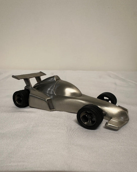 Metallic object with wheels on a white background