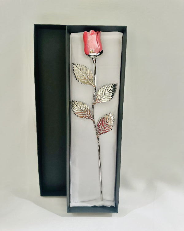 Decorative rose with pink flower and silver leaves in a black box on a white background