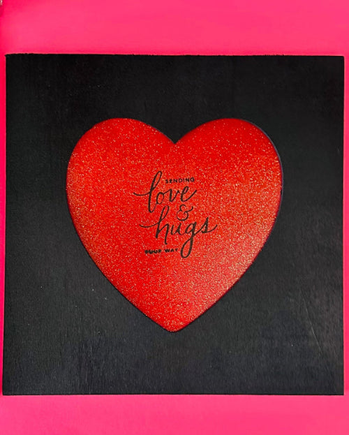 Red heart-shaped object with 'love & hugs' text on a black background. Gift Ready
