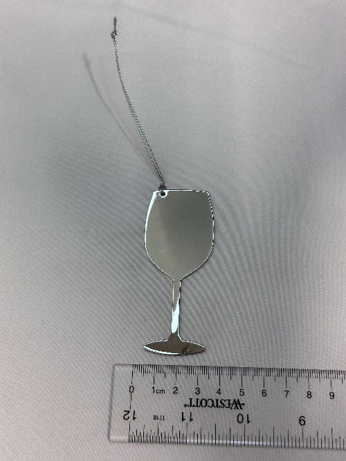 Small silver spoon next to a ruler on a white background