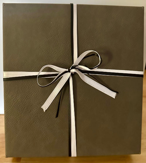Brown gift box with a white ribbon on a wooden surface