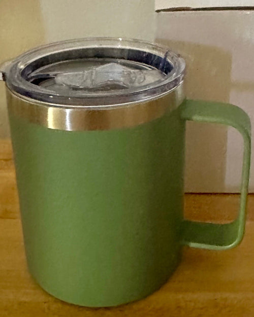 Green insulated mug with a clear lid on a wooden surface