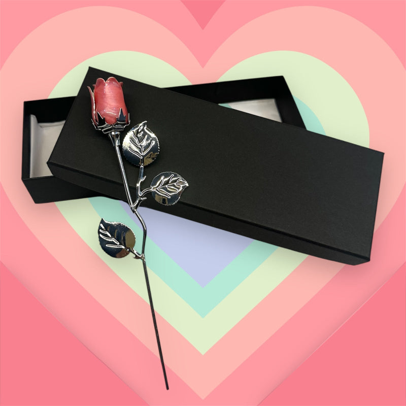 Decorative rose with silver leaves in a black box on a heart-shaped background