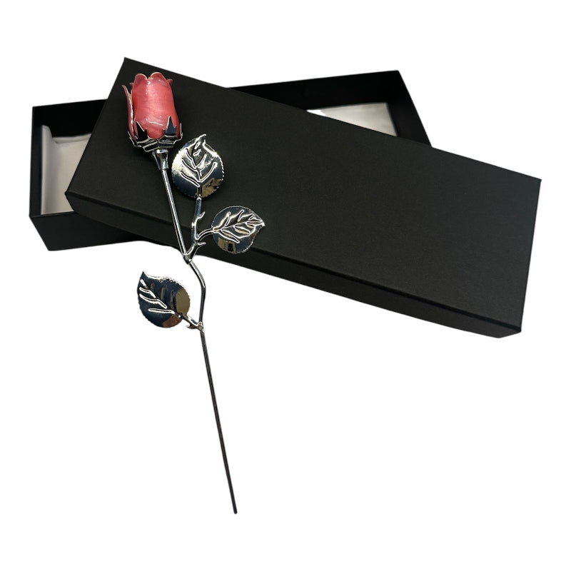 Silver rose with pink gem in a black box on a white background