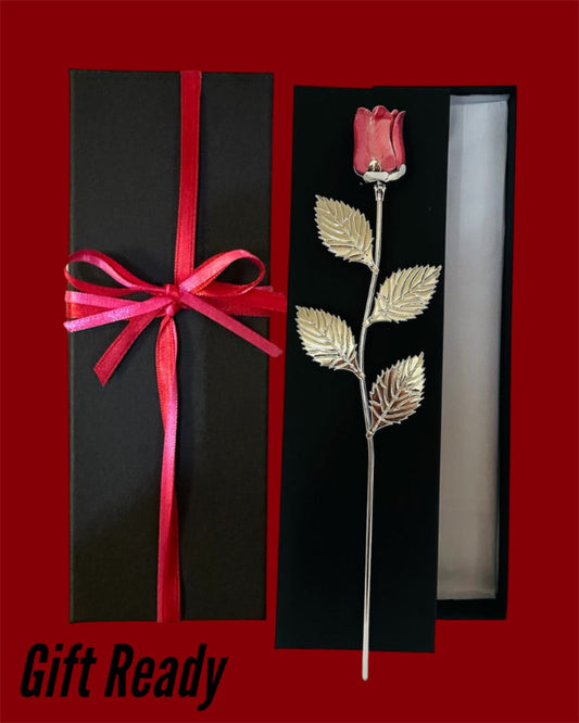 Decorative rose with gold leaves in a black box with a red ribbon gift ready 