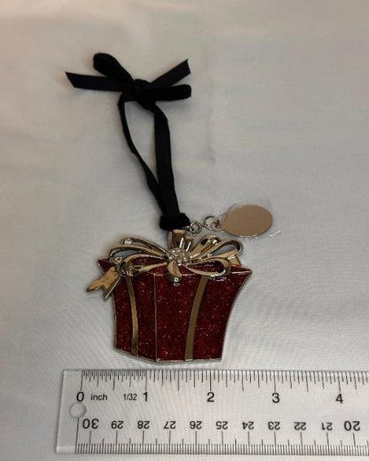 Decorative gift box charm, Christmas Ornament With a black ribbon next to a ruler on a white background