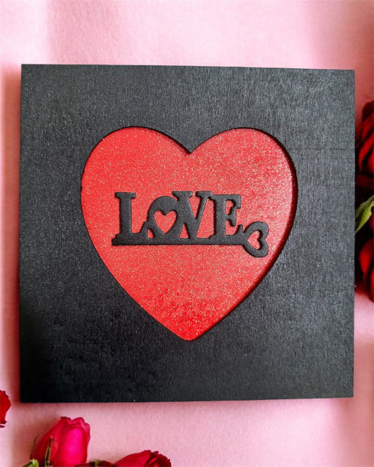 Red heart with 'LOVE' text on a black background surrounded by red roses.