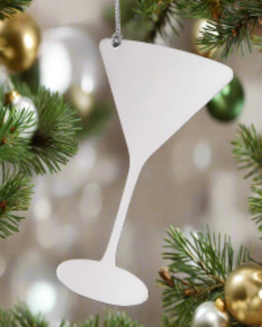 White martini glass ornament hanging on a Christmas tree with gold and green ornaments.