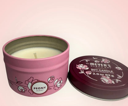 Pink candle tin with 'Mever's' branding and 'Peony' scent on a pink background