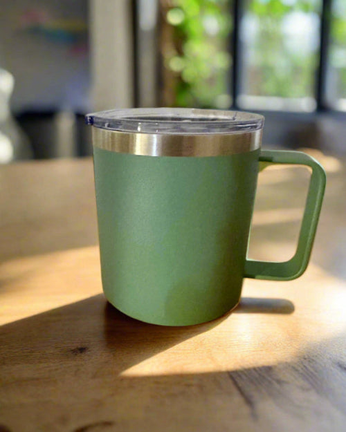 Green insulated mug with a handle on a wooden surface