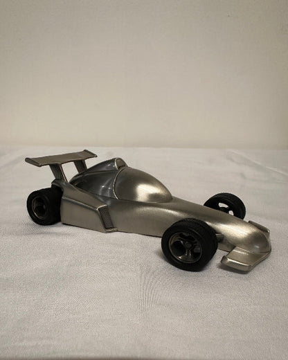 Metallic object with wheels on a white background