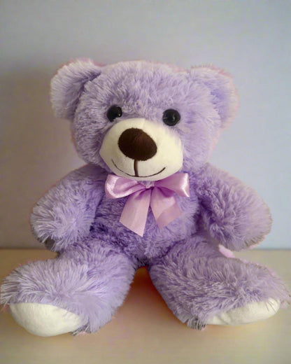 Purple teddy bear with a pink bow on a light background