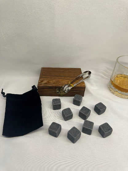 Set of gray stones with a wooden container and black pouch on a white background