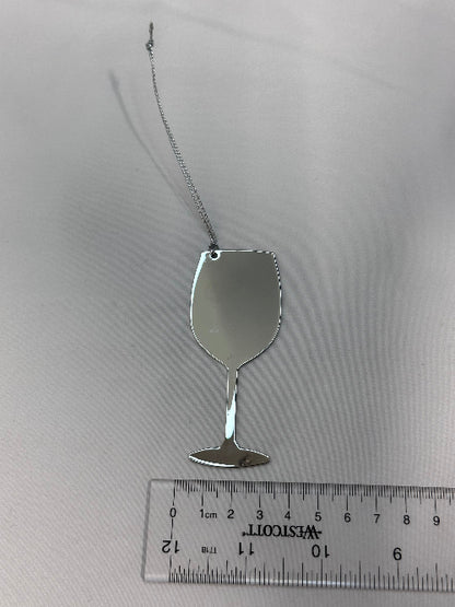 Small silver spoon next to a ruler on a white background