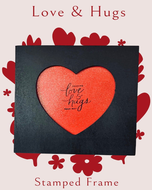 Stamped frame with a red heart and 'Love & Hugs' text on a decorative background with hearts and flowers.